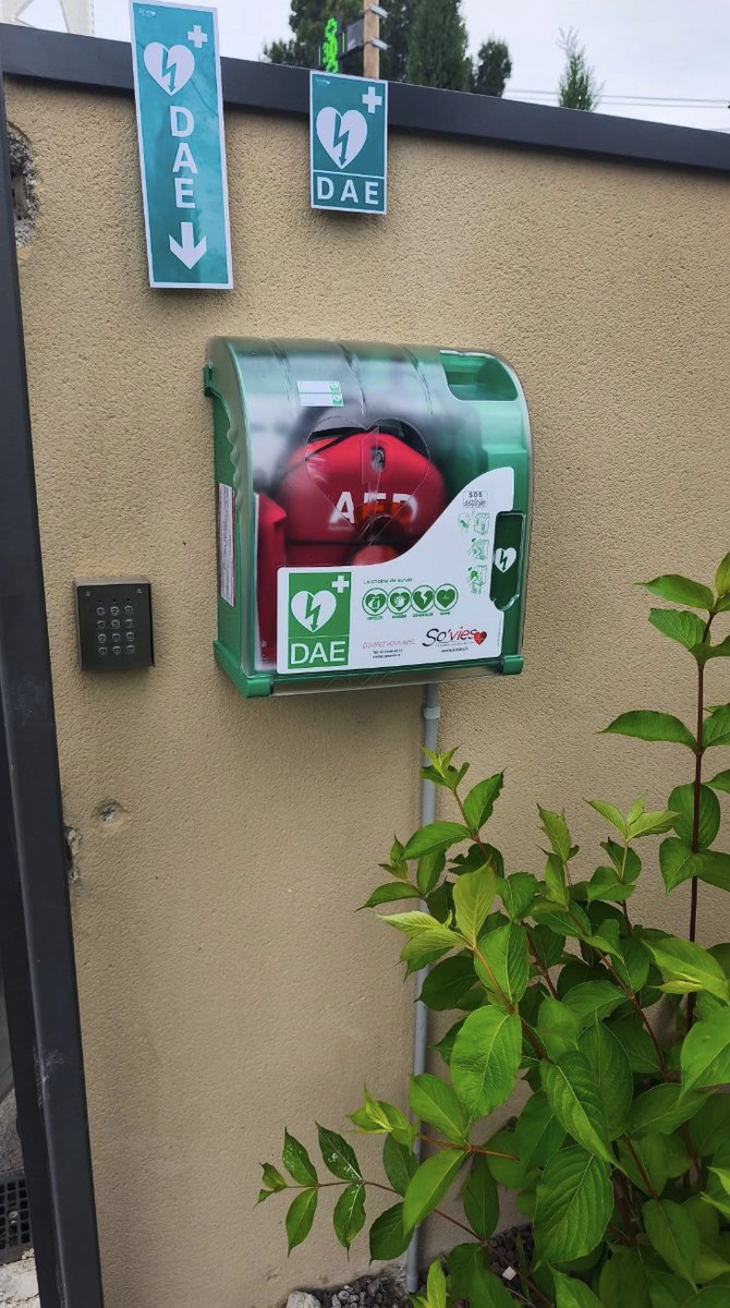 Défibrillateur (DAE) installé et raccordé sur une façade, avec signalétique