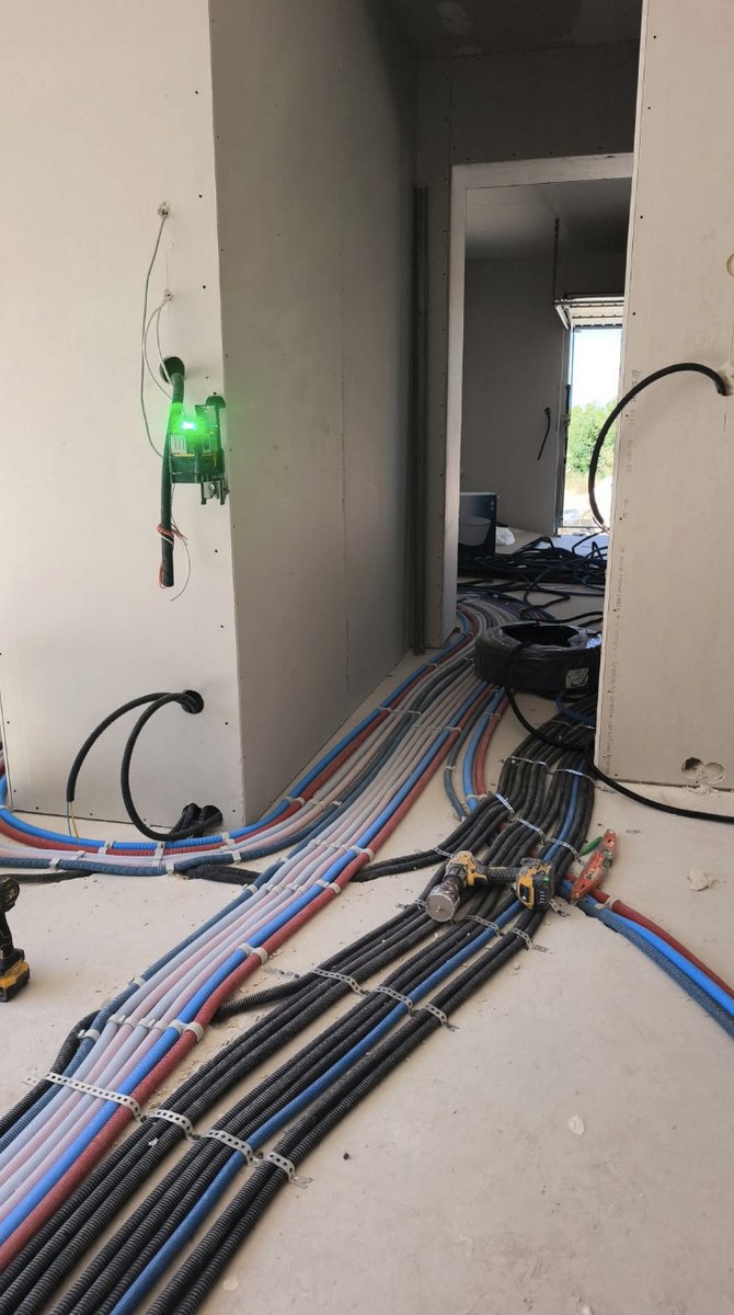 Tirage de gaines électriques repérées et clipsées sur un chantier